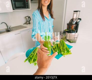 Frischer Selleriedetox-Saft. Gesunde Frau behandelt mit frisch gepresstem Sellerie-Saft. Gesunde Ernährung und Trinken Stockfoto