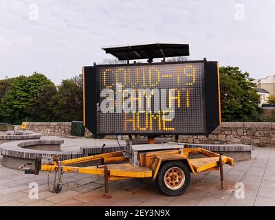 BRAY, IRLAND - 24. Apr 2020: Mobiles elektronisches Verkehrsschild zeigt die Meldung "COVID-19 STAY AT HOME" in Bray Town, Co. Wicklow, Irland an. Stockfoto