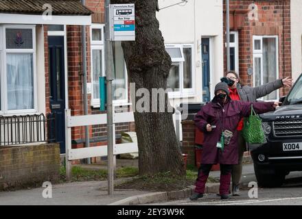 Coalville, Leicestershire, Großbritannien. 5th. März 2021. Frauen mit Gesichtsbezügen hageln einen Bus. North West Leicestershire hat die höchste Coronavirus-Rate in England nach den neuesten Public Health England Zahlen. Credit Darren Staples/Alamy Live News. Stockfoto