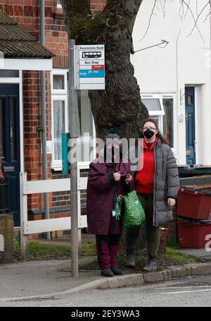 Coalville, Leicestershire, Großbritannien. 5th. März 2021. Frauen warten an einer Bushaltestelle. North West Leicestershire hat die höchste Coronavirus-Rate in England nach den neuesten Public Health England Zahlen. Credit Darren Staples/Alamy Live News. Stockfoto