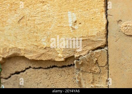 Eine Hauswand mit einem großen Riss. Grunge Betonzementwand mit einem Riss in einem Industriegebäude. Stockfoto