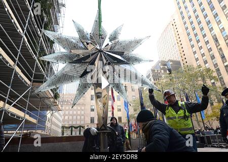 Arbeiter fhren den Swarovski-Stern, whrend er seinen Aufstieg in Richtung  der Spitze des 85-Fu-Rockefeller Center Weihnachtsbaum am 13. November 2014  beginnt. Der Stern mit 25.000 Kristallen und einem Gewicht von 550 Pfund  wird auf dem ...