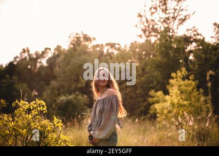 Happy Teenager-Mädchen mit Kamera im Sommer Wald stehen Stockfoto