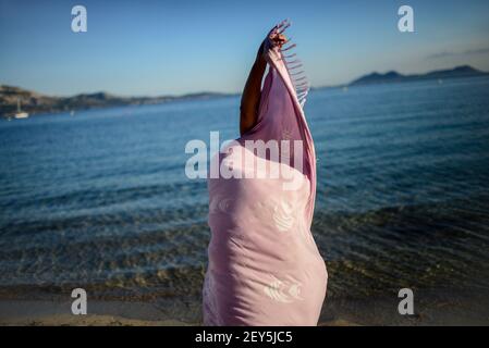 Junge Frau tanzt am Strand mit Sarong Stockfoto