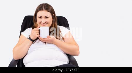 Geschäftsfrau trinkt Kaffee oder Tee während der Arbeit. Plus Größe junge Frau zu Hause bleiben während Quarantäne. Selbstisolierung als Prävention. Arbeiten Stockfoto