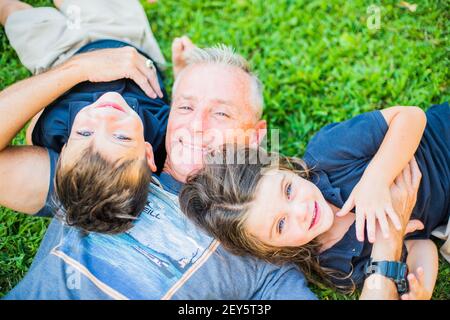 ZWILLINGE, DIE MIT PAPA HERUMGODELN Stockfoto