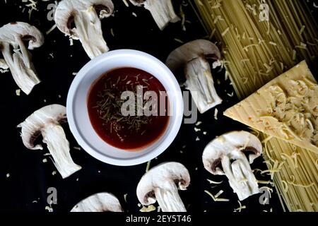 Gehackte Pilze mit Pasta und Käse auf schwarzem Hintergrund Stockfoto