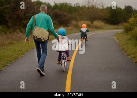 LERNEN, EIN FAHRRAD MIT PAPA ZU FAHREN Stockfoto