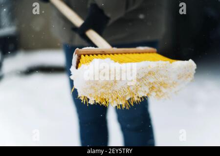 Frau entfernt Schnee von seinem Hof nach einem Schneesturm, Schaufeln sn Stockfoto