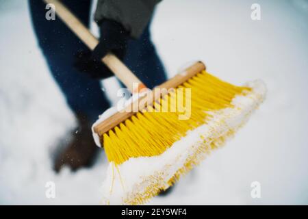 Frau entfernt Schnee von seinem Hof nach einem Schneesturm, Schaufeln sn Stockfoto