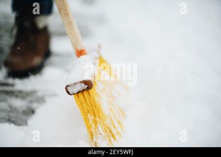 Frau entfernt Schnee von seinem Hof nach einem Schneesturm, Schaufeln sn Stockfoto