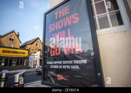 Das umrahmte Poster „The Shows will Go On“ hing an der Außenseite des Wimbledon Theatre, während die Londoner Theater während der Coronavirus-Sperre geschlossen bleiben Stockfoto