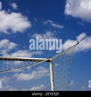 Ein weißes Fußball-Tornetz auf dem bewölkten Himmel Hintergrund Stockfoto