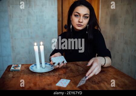 Wählen Sie eine Karte aus den Händen eines Wahrsager. Eine Frau erzählt Vermögen während eines magischen Rituals. Glaube an Mystik Stockfoto