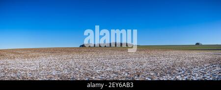 Blauer Himmel über lückenigem Schnee auf Feldern in Hampshire, England. Hochauflösendes Panoramabild. Stockfoto