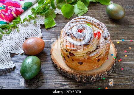 Osterkuchen, bemalte Eier, grüne Zweige auf einem Holztisch. Frühlingsferien Hintergrund Stockfoto