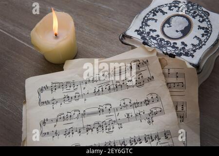 Musiknoten auf altem Papier und Kerzen auf dem Tisch Stockfoto