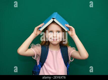 Kind Mädchen mit einer Schultasche und Bücher in den Händen Stockfoto