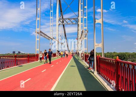 Kiew, Ukraine - 28. Juli 2018: Unbekannte gehen über die Fußgängerbrücke (Parkbrücke) über den Dnjepr Fluss Stockfoto
