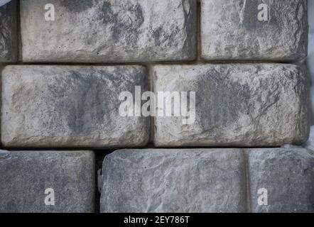 Der Mensch machte Steine Steine geformt wie Ziegel Nahaufnahme von Stein oder Ziegelwand zusammen Gebäude außen oder Landschaftsbau horizontalen Hintergrund gestapelt Stockfoto