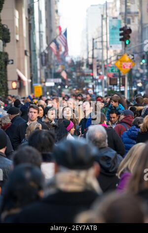 Während der Winterferiensaison in Midtown Manhattan, New York City, NY USA, geht eine Menschenmenge auf der Fifth Avenue spazieren. Stockfoto