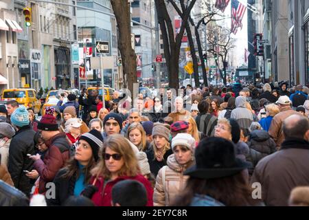 Während der Winterferiensaison in Midtown Manhattan, New York City, NY USA, geht eine Menschenmenge auf der Fifth Avenue spazieren. Stockfoto