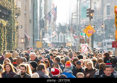 Während der Winterferiensaison in Midtown Manhattan, New York City, NY USA, geht eine Menschenmenge auf der Fifth Avenue spazieren. Stockfoto