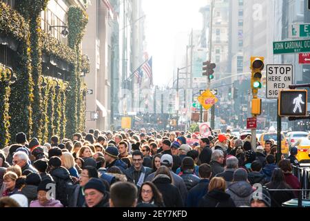 Während der Winterferiensaison in Midtown Manhattan, New York City, NY USA, geht eine Menschenmenge auf der Fifth Avenue spazieren. Stockfoto