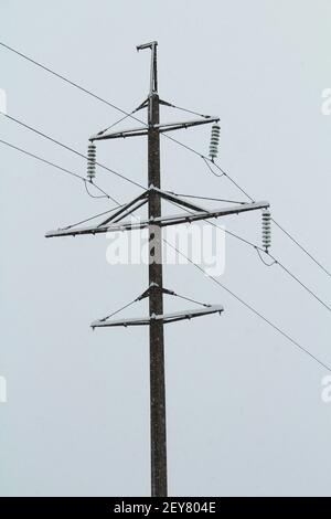Hölzerne Pol-Stromleitung auf Winterhimmel blau. Stock Foto mit leerem Platz für Text und Design. Stockfoto