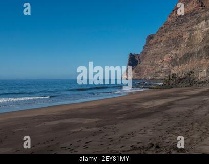 Blick auf den leeren Sandstrand Playa de Guigui mit felsigen Klippen im westlichen Teil der Insel Gran Canaria, nur zu Fuß von Barranco de Guigui erreichbar Stockfoto