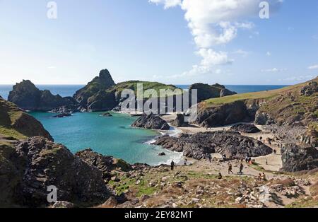 Familien genießen einen sonnigen Tag im Oktober auf dem Tiefstand Gezeitenstrand in Kynance Cove auf der Halbinsel Lizard in Cornwall, Großbritannien Stockfoto