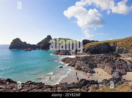 Familien genießen einen sonnigen Tag im Oktober auf dem Tiefstand Gezeitenstrand in Kynance Cove auf der Halbinsel Lizard in Cornwall, Großbritannien Stockfoto