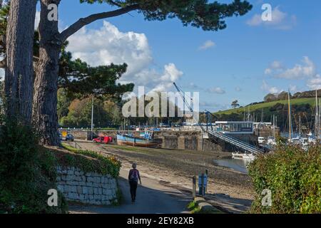 Ein Spaziergänger auf dem Küstenwanderweg von Penryn nähert sich bei Ebbe dem Mylor Yatch Hafen in der Nähe von Falmouth in Cornwall. Stockfoto