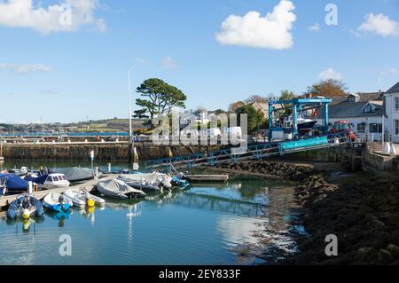 Ein Boot wird mit einem Traktor vom Wasser weg transportiert Zur Lagerung im Mylor Yacht Hafen bei Falmouth in Cornwall Stockfoto