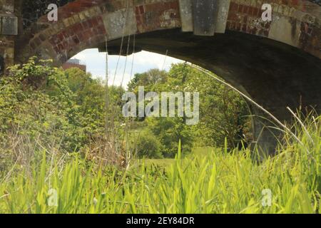 Solides Mauerwerk einer Brücke über einen Bach Stockfoto