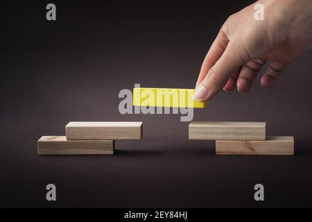 Hand Gebäude Pyramide mit leeren Holzblöcken, symbolisiert Karriere Leiter. Leader-Konzept Stockfoto