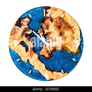 Schöne runde Wanduhr aus Holz aus Baumwurzel und blauem Epoxidharz auf weißem Hintergrund isoliert. Stockfoto