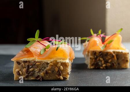 Cerealien Brot Sandwiches mit cremigem Käse, geräuchertem Lachs und Micro Greens auf einem Tisch Stockfoto