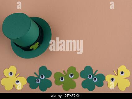 St. Patricks Day Kobold Hut und Kleeblätter mit Cartoon-Kunststoff-Augen. Draufsicht. Stockfoto