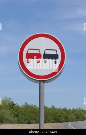 Straßenschild, das Überholverbot verbietet. Warnung für Fahrer auf gefährlichem Straßenabschnitt. Stockfoto