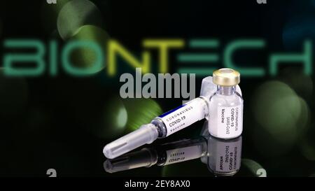 Schlesien, Polen, März 2021: BioNTech Coronavirus-Impfstoff in Ampulle und Spritze auf schwarzem Hintergrund. Impfstoff für das COVID-19-Viruskonzept. Ampulle Stockfoto