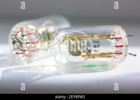 Zwei alte elektronische Vakuum-Radioröhren isoliert auf weißem Hintergrund. Transparente Lampen von der Sowjetunion hergestellt. Transistoren mit Glasröhren, Oldtimer-Klo Stockfoto