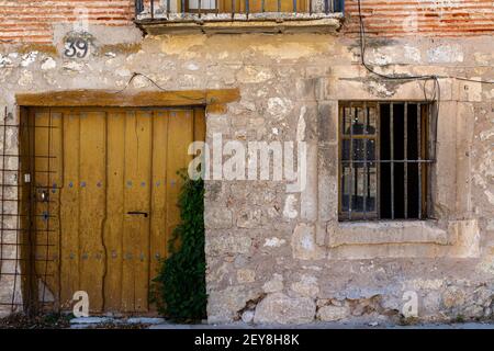 Detail einer großen, alten, gelben Tür in der Fassade eines alten Hauses Stockfoto