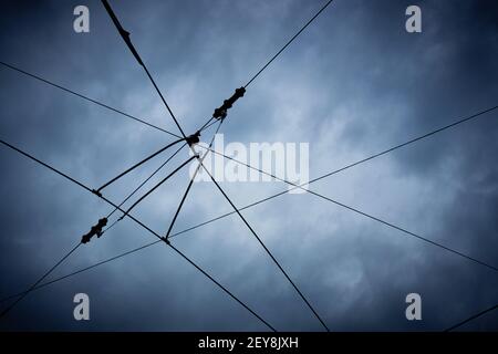 Alte hölzerne elektrische Straßenpfosten mit vielen Drähten. Elektrische Drähte gegen den blauen Himmel Stockfoto