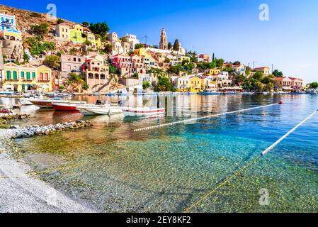 Symi Island, Griechenland. Griechische Inseln Urlaub Reise Touren Ziel von Rhodos, Ägäis. Bunte türkische neoklassizistische Häuser in der Bucht von Symi. Stockfoto