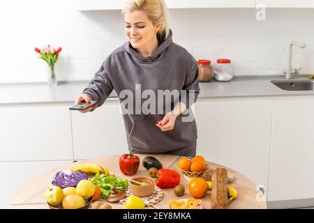 Frau mit Kalorienzähler Anwendung auf ihrem Smartphone Stockfoto