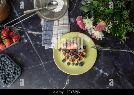 Ein Blick von oben auf frisch gebackene Wiener Waffeln mit Heidelbeeren, Erdbeeren und Schokolade Stockfoto