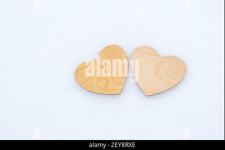 Valentinstag, zwei hölzerne Herzen liegen auf weißem Schnee Stockfoto