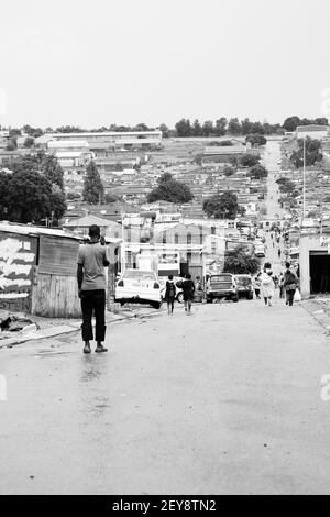 JOHANNESBURG, SÜDAFRIKA - 06. Januar 2021: Johannesburg, Südafrika - 17. Januar 2011: Afrikanische Menschen gehen eine Hauptstraße in Alexandra Townshi entlang Stockfoto