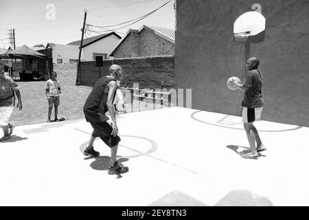JOHANNESBURG, SÜDAFRIKA - 06. Jan 2021: Soweto, Südafrika - 11. Dezember 2010: Afrikanische Kinder spielen auf öffentlichen Spielplatz Basketballplatz Stockfoto